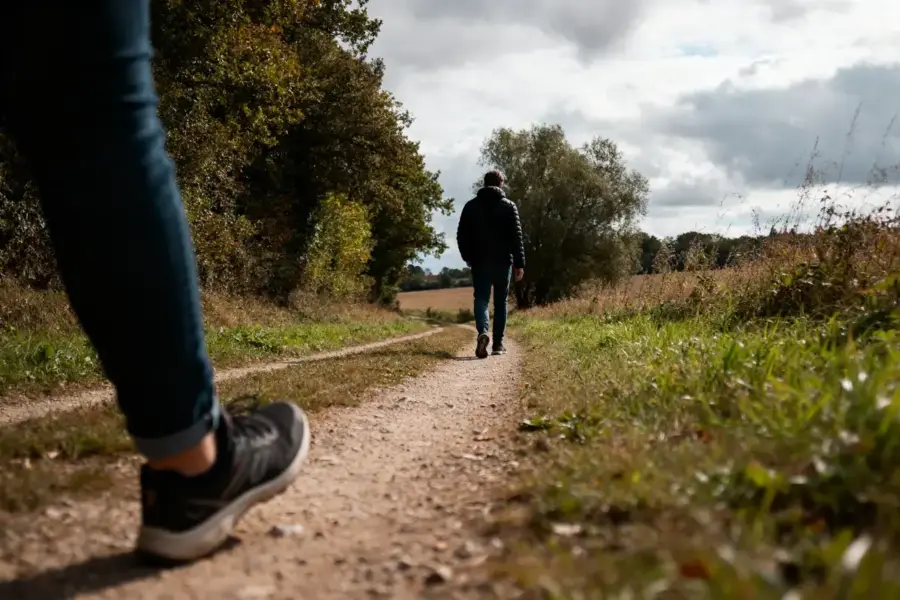 Deux personnes marchant sur un sentier naturel illustrant 20000 pas en km quotidiennement