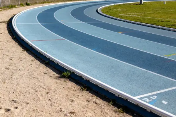 Virage d'une piste de course extérieure avec surface bleue et lignes marquées