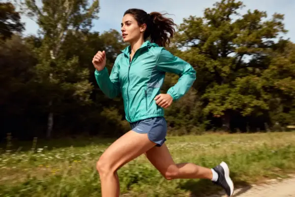 Femme courant en extérieur portant une tenue running femme confortable et sportive.